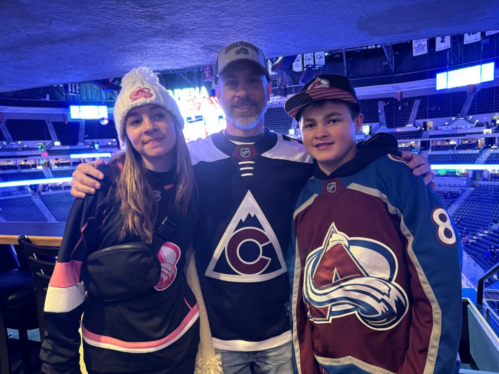 Image of real CREXONT patient, Stuart, with his two children at a hockey game.